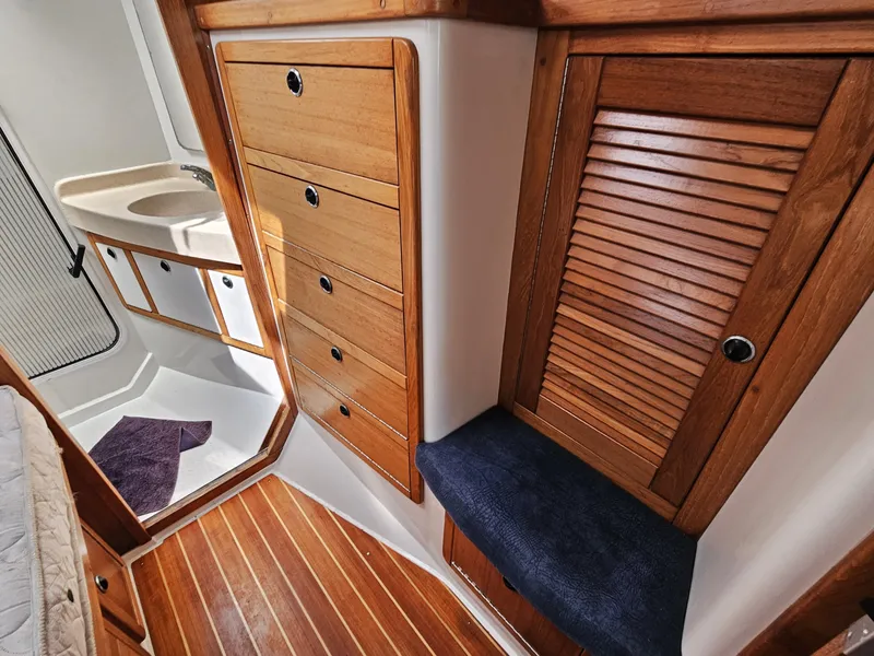 Slide: The Image of Interior of a 1999 Catalina 42 MkII featuring wooden cabinetry and a small sink. - 21