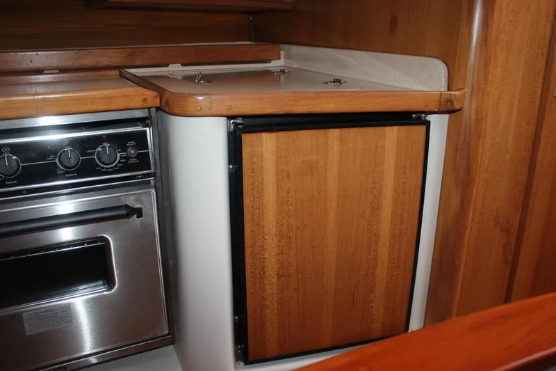 Slide: The Image of The galley of a 1999 Catalina 42 MkII with wooden cabinets and a stainless steel oven. - 29