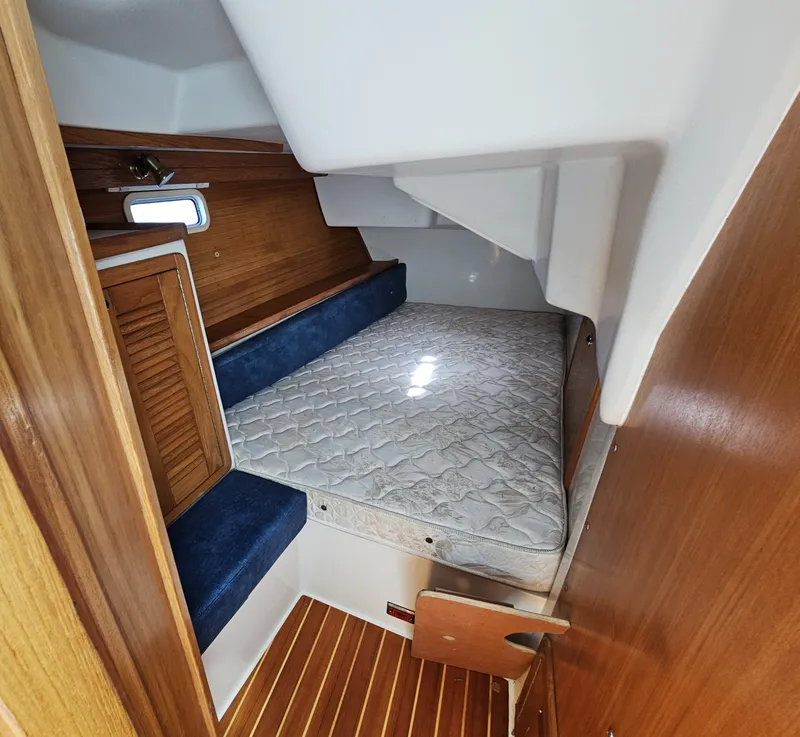 Slide: The Image of The cabin of a 1999 Catalina 42 MkII with a double bed and wooden features. - 42