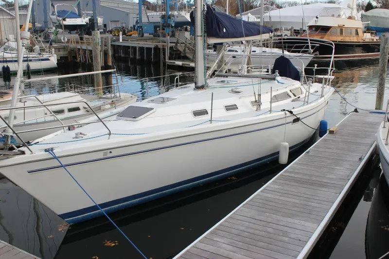 Slide: The Image of A white sailboat is docked, featuring a blue line and cover. Other boats are in the background. - 2
