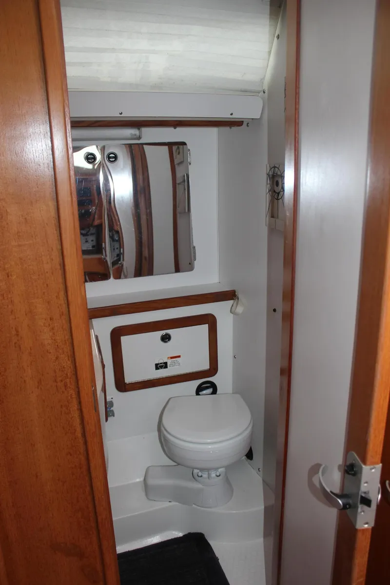 Slide: The Image of The image shows a boat bathroom with a toilet and a mirror. - 39
