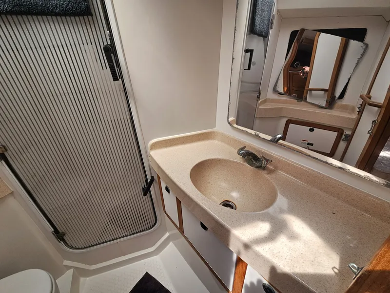 Slide: The Image of The image shows the bathroom of a 1999 Catalina 42 MkII with a sink and mirror. - 18