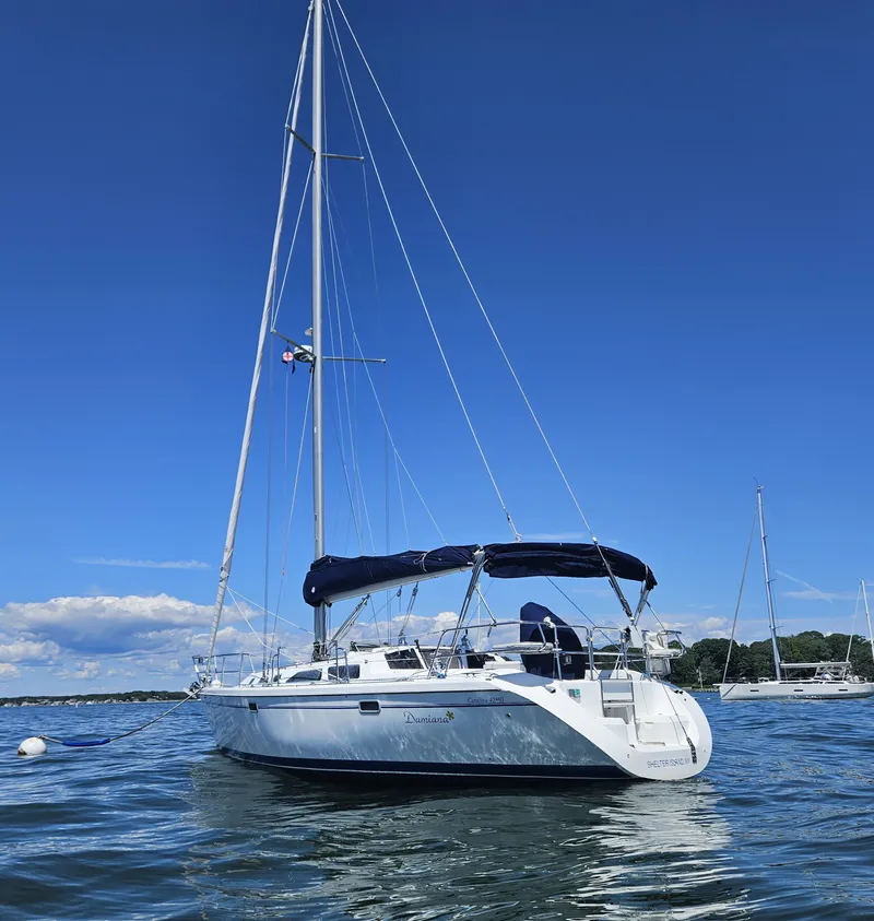 Slide: The Image of A white sailboat with a blue bimini sits on calm water under a clear sky. - 4