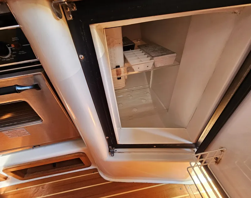 Slide: The Image of An open refrigerator in the galley of a 1999 Catalina 42 MkII, next to an oven. - 30