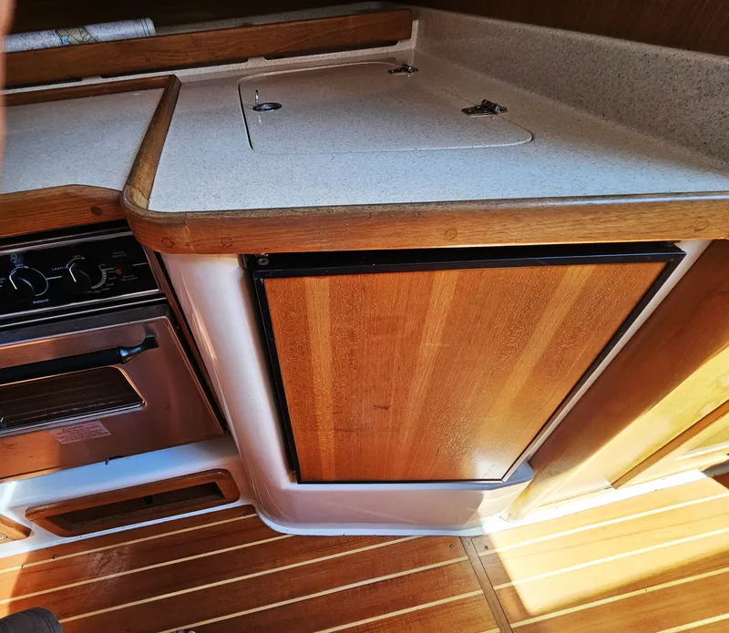 Slide: The Image of The galley of a 1999 Catalina 42 MkII with wood paneling and a built-in stove. - 32