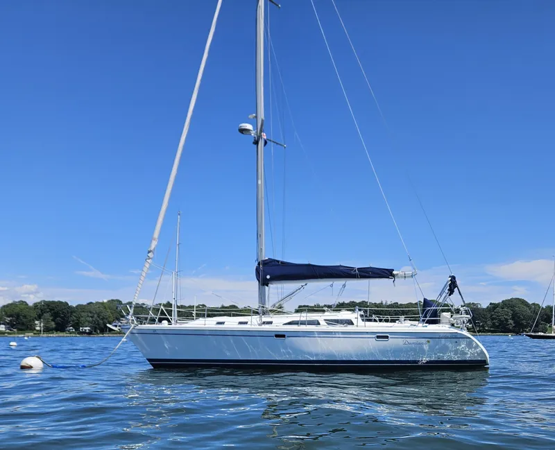 Slide: The Image of A 1999 Catalina 42 MkII is anchored on calm water, surrounded by trees. - 3