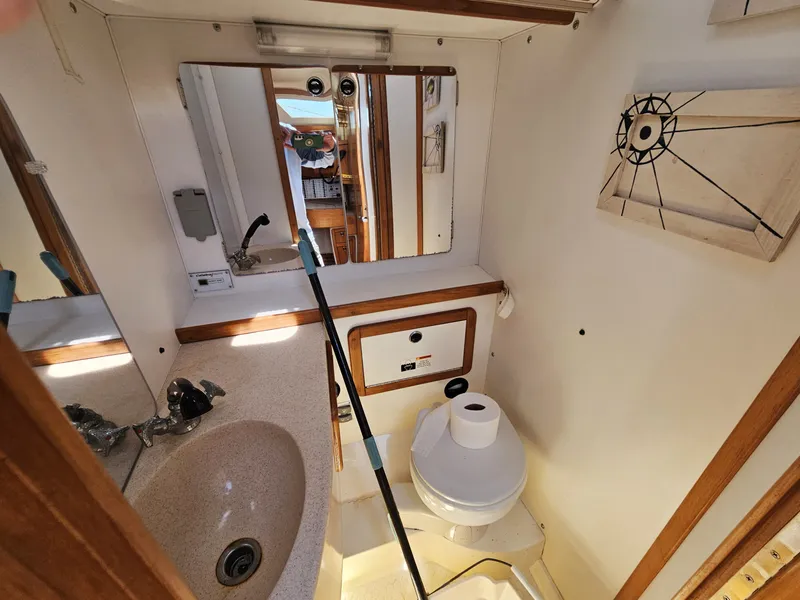 Slide: The Image of The image shows a boat bathroom with a sink, toilet, and mirror. - 40
