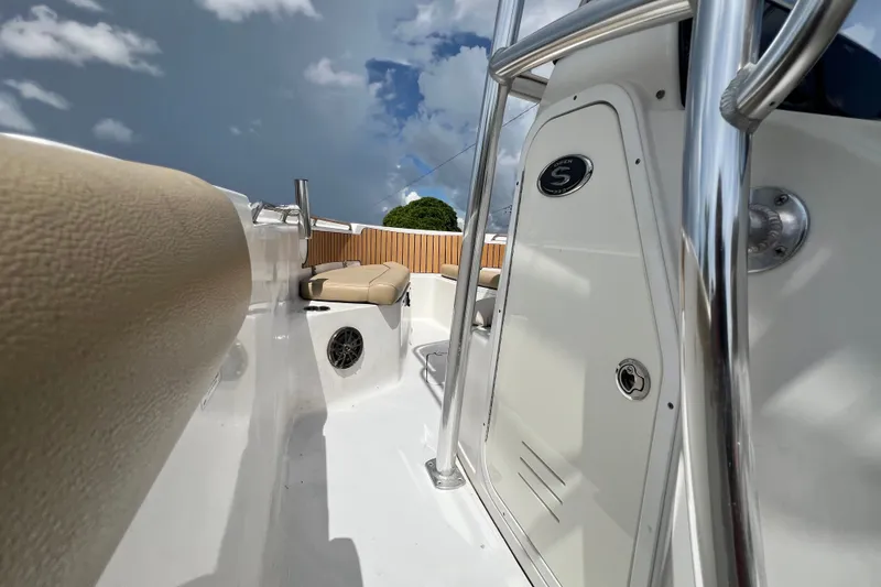 Slide: The Image of 2016 Sportsman Heritage 231 Center Console boat interior with seating and chrome details under a cloudy sky. - 28