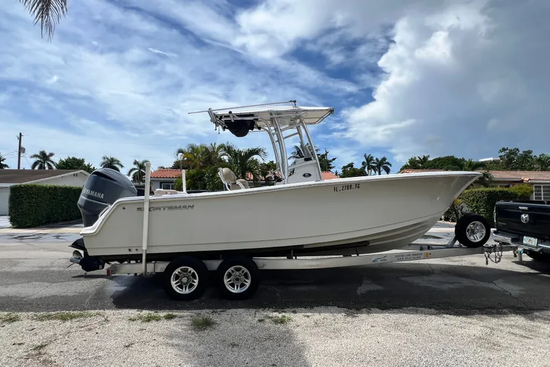 Slide: The Image of 2016 Sportsman Heritage 231 Center Console boat on trailer, parked outdoors under a cloudy sky. - 7