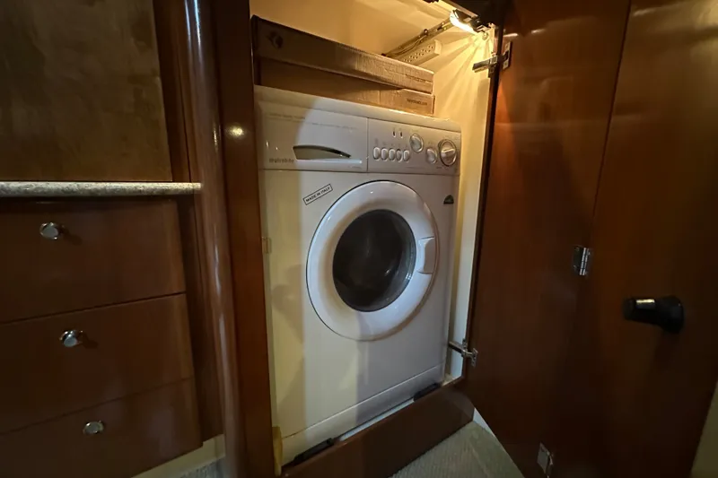 Slide: The Image of Washer-dryer unit inside 2007 Meridian 411 Sedan yacht's wooden cabinet. - 72