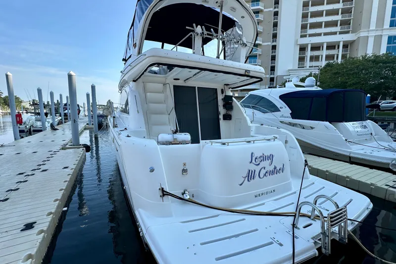 Slide: The Image of 2007 Meridian 411 Sedan yacht docked at marina, rear view with name "Losing All Control." - 16