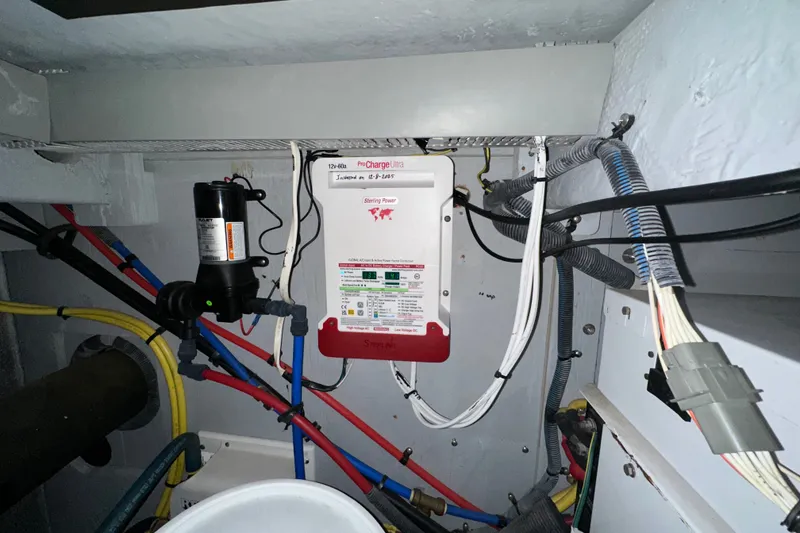 Slide: The Image of Electrical system inside a 2007 Meridian 411 Sedan boat, featuring wiring and a battery charger. - 131