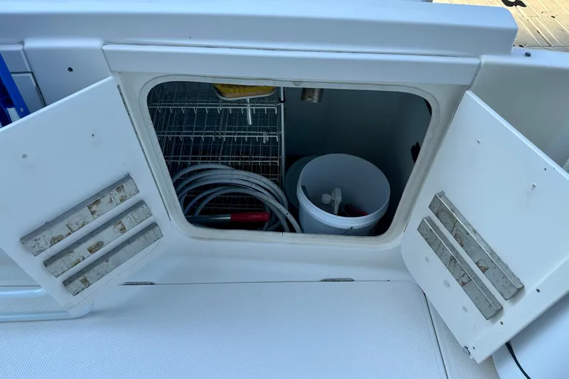 Slide: The Image of Open storage compartment on 2007 Meridian 411 Sedan boat with hoses and bucket. - 33
