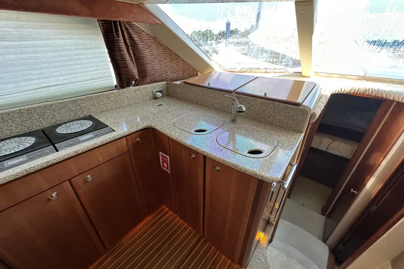 Slide: The Image of Luxurious 2007 Meridian 411 Sedan yacht kitchen with modern amenities and elegant wood cabinetry. - 60