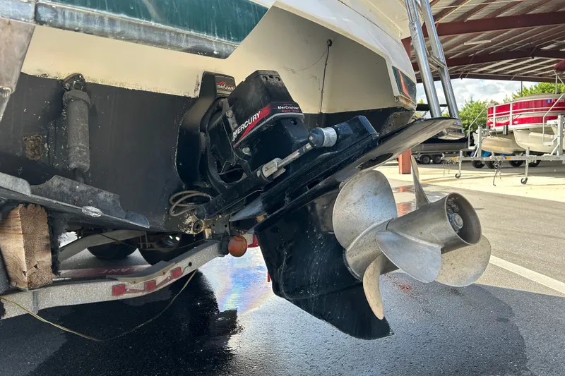 Slide: The Image of 1998 Cobalt 293 boat with MerCruiser outdrive and propeller, parked under a metal canopy. - 16
