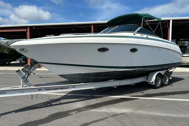 Slide: The Image of 1998 Cobalt 293 boat on trailer, parked outdoors under blue sky. - 4