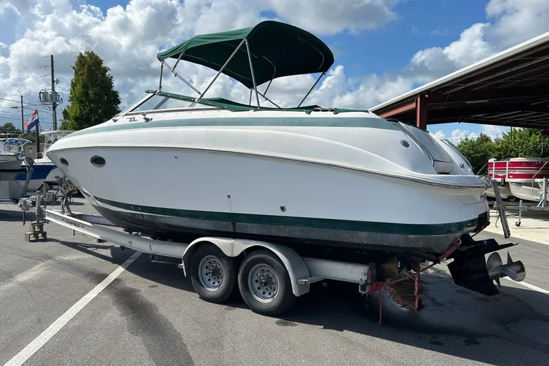 Slide: The Image of 1998 Cobalt 293 boat on trailer with green canopy, parked outdoors. - 3