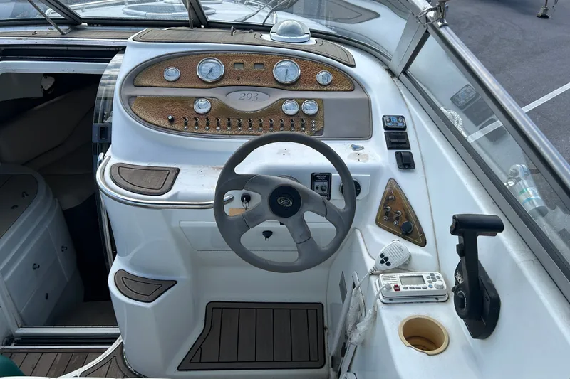 Slide: The Image of 1998 Cobalt 293 boat dashboard with steering wheel and control panel. - 8