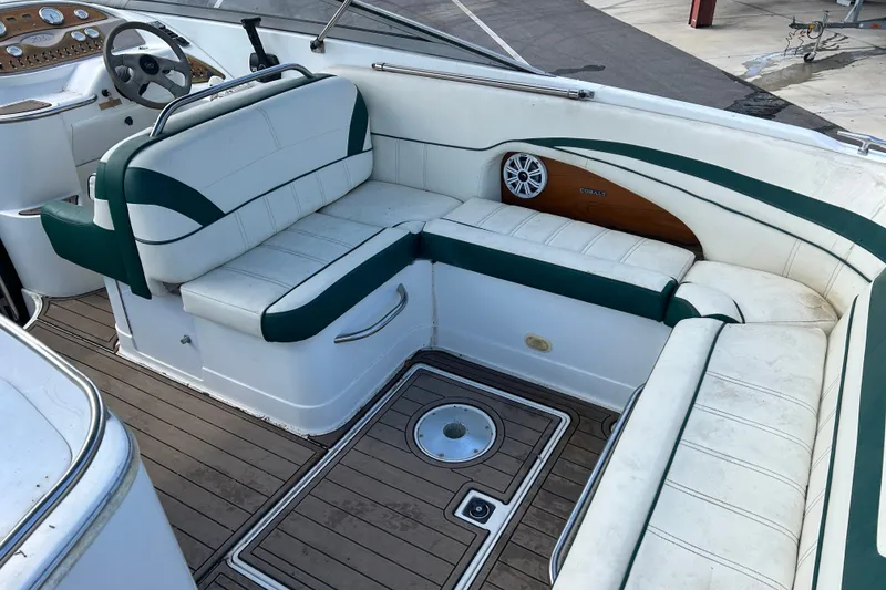 Slide: The Image of 1998 Cobalt 293 boat interior with white and green seating, wooden accents, and steering wheel. - 10