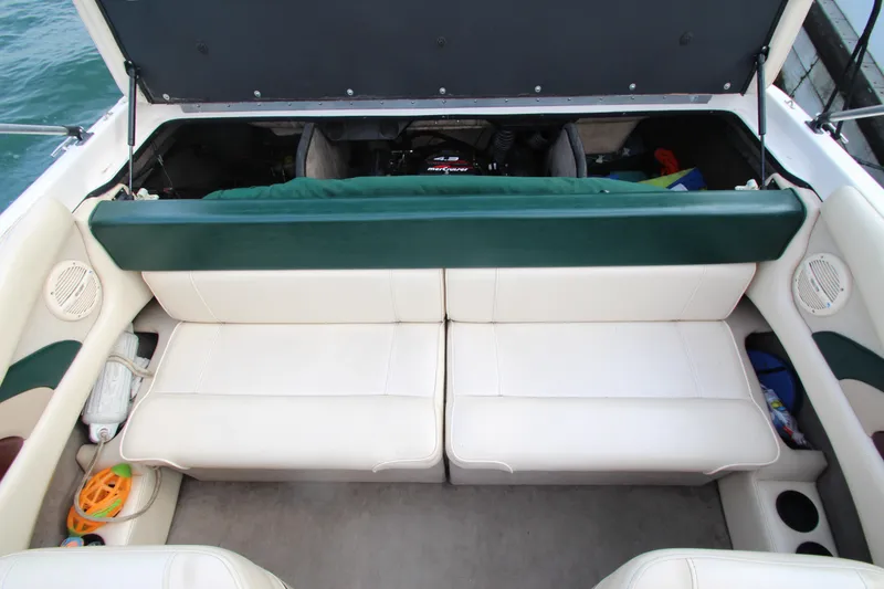 Slide: The Image of 1999 Bryant 182 boat interior with white seating and open engine compartment. - 19