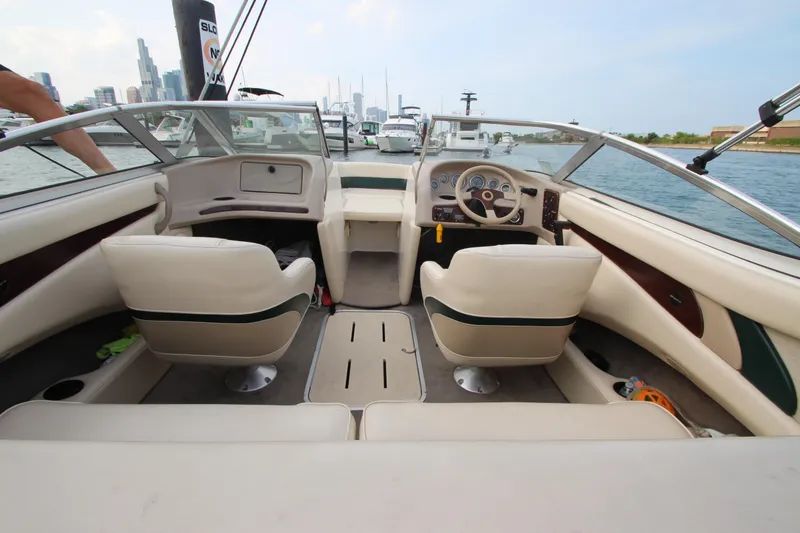 Slide: The Image of Interior of a 1999 Bryant 182 boat with beige seating and steering wheel. - 21