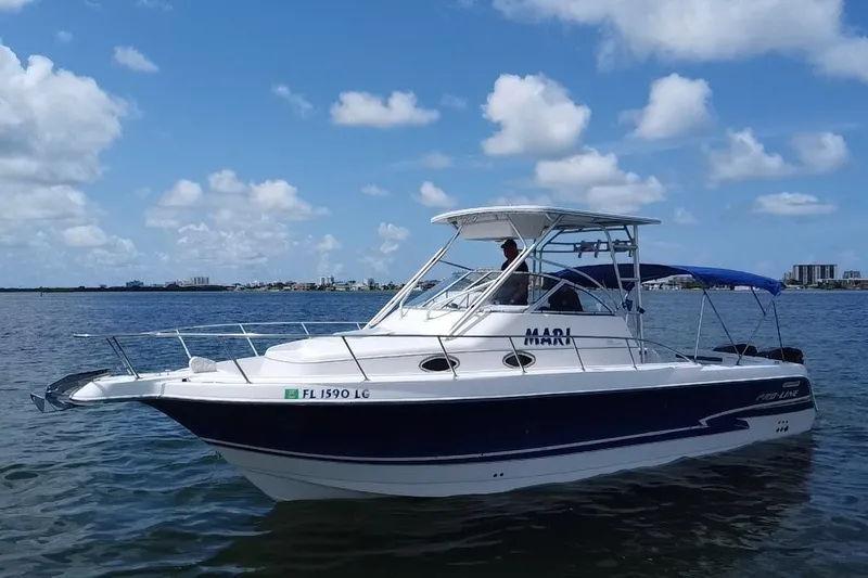The Image of 2000 Pro-Line 30 Walkaround boat on calm water under a blue sky. - 20