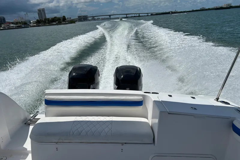 Slide: The Image of 2000 Pro-Line 30 Walkaround boat cruising with twin engines, leaving a wake behind. - 22