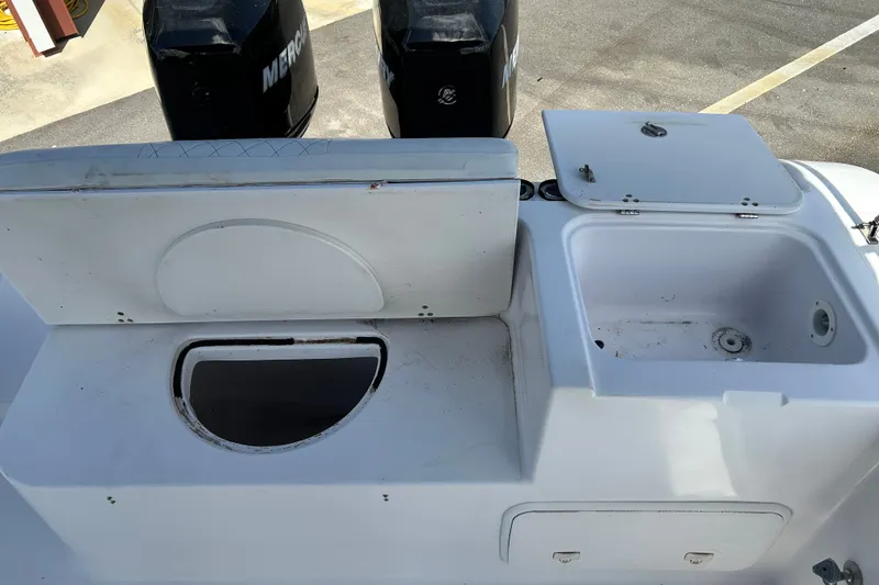 Slide: The Image of 2000 Pro-Line 30 Walkaround boat deck with storage compartments and dual Mercury engines. - 19