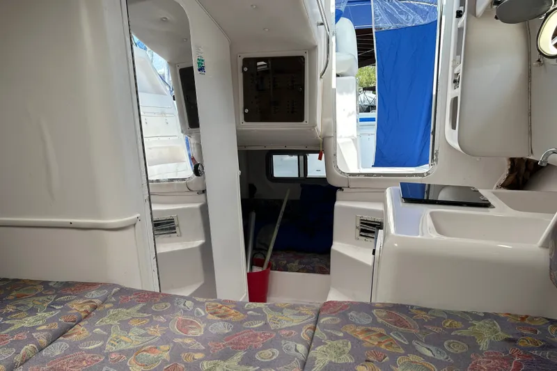 Slide: The Image of Interior of 2000 Pro-Line 30 Walkaround boat with patterned seating and white cabinetry. - 15