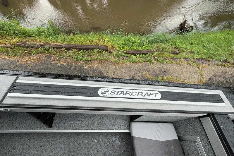 Slide: The Image of Starcraft Fishmaster 196 boat by riverside, showcasing sleek design and branding. - 27