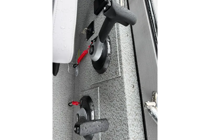 Slide: The Image of Close-up of controls on a 2027 Starcraft Fishmaster 196 boat, featuring throttle levers. - 23