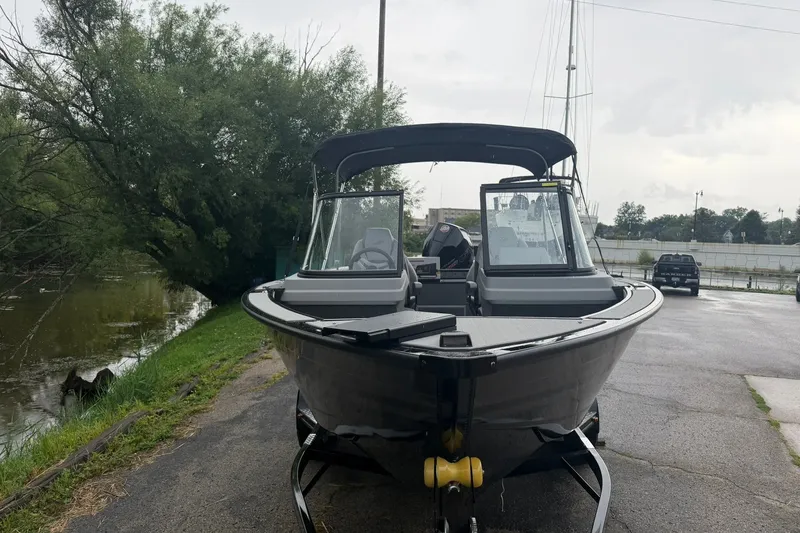 Slide: The Image of 2027 Starcraft Fishmaster 196 boat on trailer near a riverbank. - 3