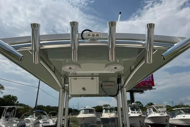 Slide: The Image of 2024 KenCraft 2460 Bayrider boat with rod holders and T-top, docked under a cloudy sky. - 24