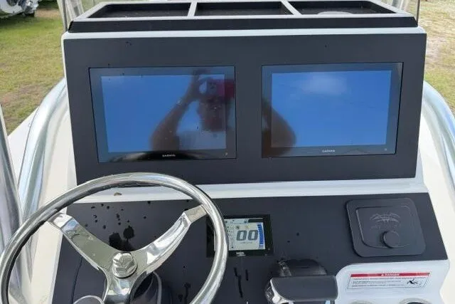 Slide: The Image of 2024 KenCraft 2460 Bayrider dashboard with dual Garmin screens and steering wheel. - 27