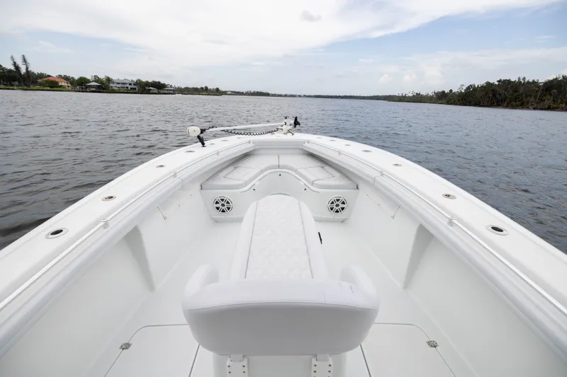 Slide: The Image of 2019 Yellowfin 36 Offshore boat interior with white seating, on a calm waterway. - 15