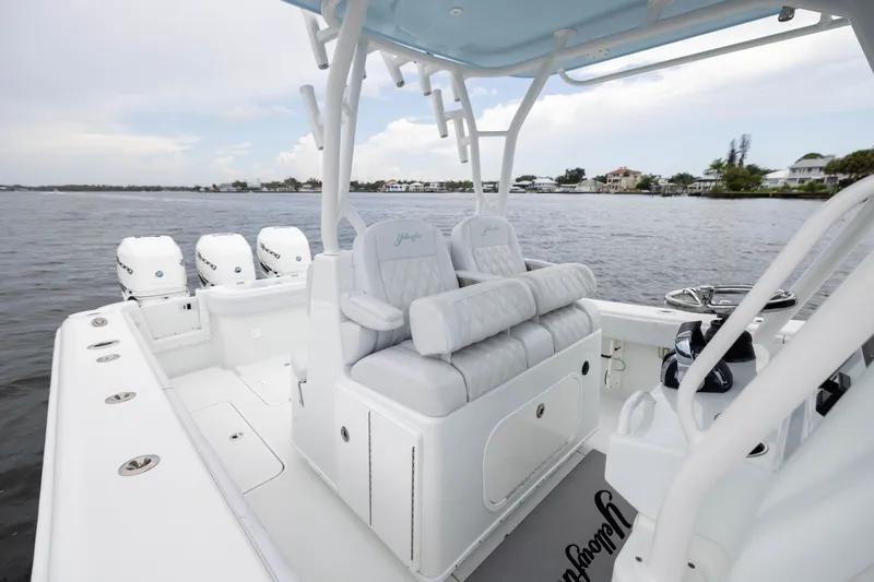 Slide: The Image of 2019 Yellowfin 36 Offshore boat interior with seating and multiple engines on a calm waterway. - 34