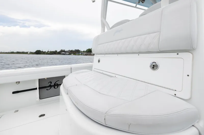 Slide: The Image of 2019 Yellowfin 36 Offshore boat with white cushioned seating, docked by calm waters. - 40