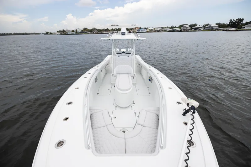 Slide: The Image of 2019 Yellowfin 36 Offshore boat on calm water, showcasing spacious deck and seating. - 18