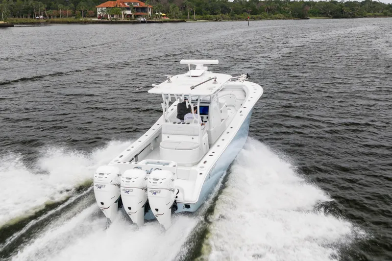 Slide: The Image of 2019 Yellowfin 36 Offshore boat cruising on water with triple outboard engines. - 11