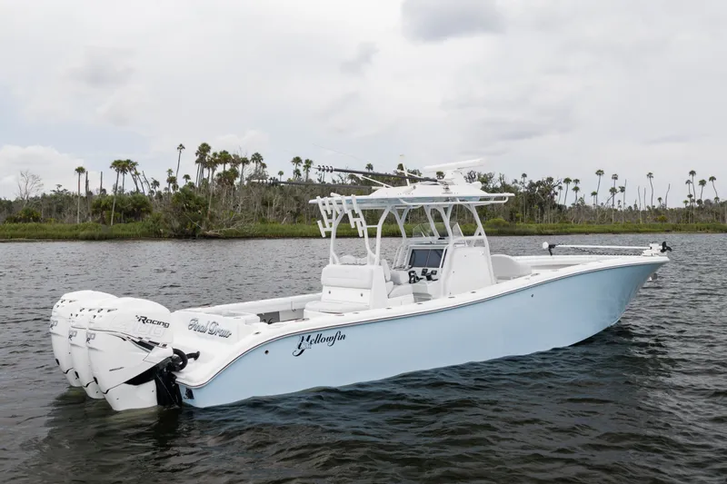 Slide: The Image of 2019 Yellowfin 36 Offshore boat on water, featuring triple outboard engines. - 2