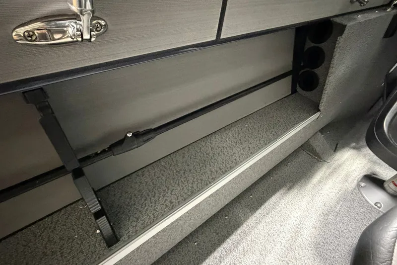 Slide: The Image of Interior storage compartment of 2027 Starcraft Fishmaster 196 boat, featuring secure rod holders. - 13