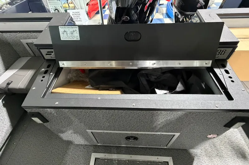 Slide: The Image of Storage compartment in a 2027 Starcraft Fishmaster 196 boat, open with items inside. - 12