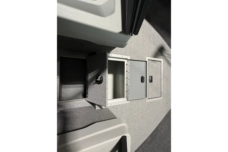 Slide: The Image of 2027 Starcraft Fishmaster 196 boat storage compartments with open hatches on a textured floor. - 14
