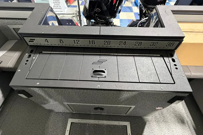 Slide: The Image of 2027 Starcraft Fishmaster 196 boat interior with measuring ruler and storage compartment. - 11