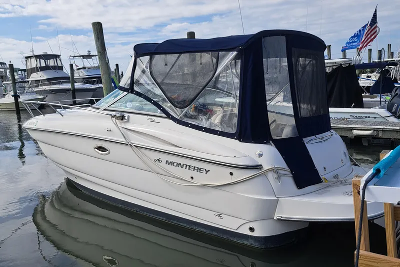 Slide: The Image of 2007 Monterey 250 Cruiser boat docked in marina with blue canopy. - 19