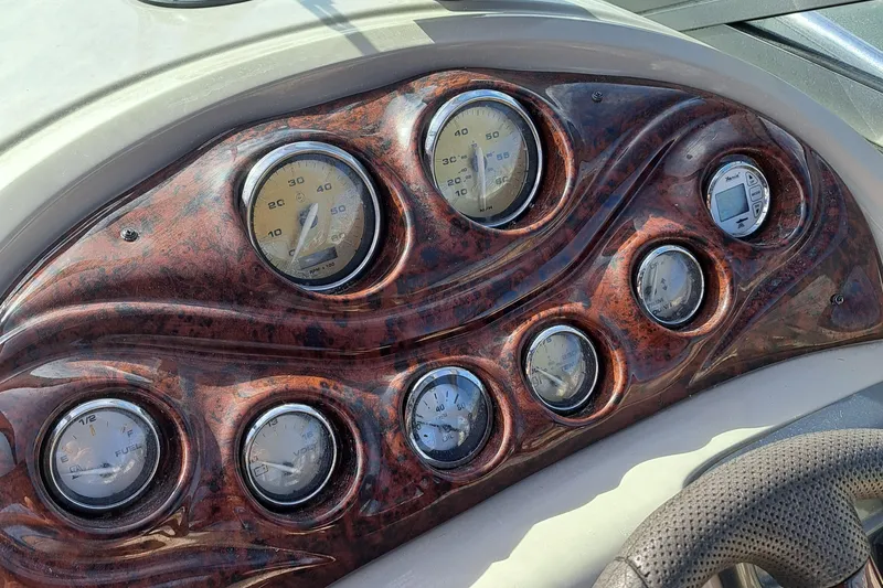 Slide: The Image of Dashboard of a 2007 Monterey 250 Cruiser boat with multiple gauges and wood finish. - 14