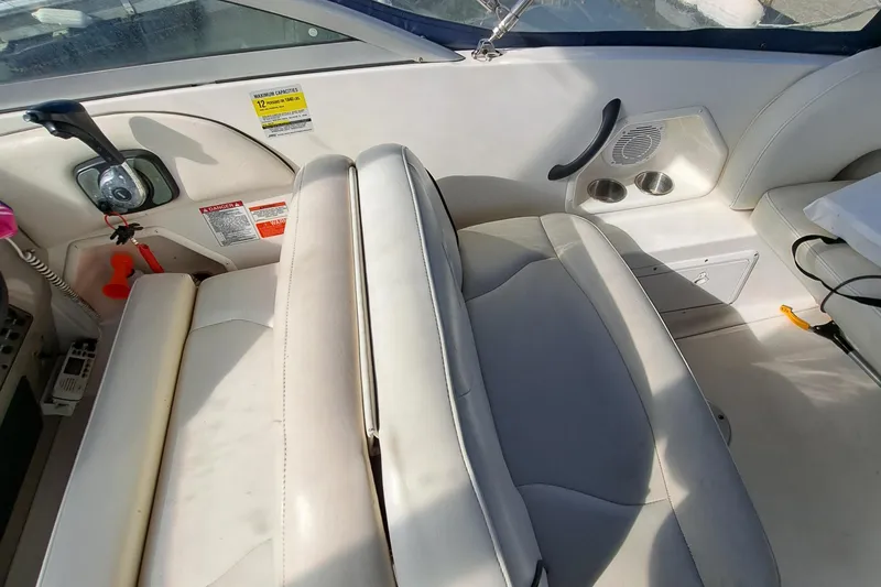 Slide: The Image of Interior of a 2007 Monterey 250 Cruiser boat with white seating and control panel. - 16