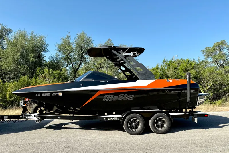 Slide: The Image of 2018 Malibu Wakesetter 21 MLX boat on trailer, parked outdoors. - 10