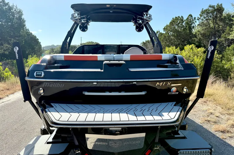 Slide: The Image of 2018 Malibu Wakesetter 21 MLX boat, rear view, parked on a scenic road. - 13
