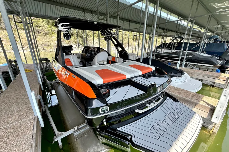 Slide: The Image of 2018 Malibu Wakesetter 21 MLX boat docked in covered marina, rear view. - 20